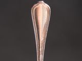 a silver spoon with a silver handle on a black surface
