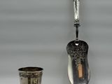 a silver spoon and cups sitting next to each other