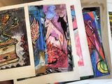 four paintings on a table with a person holding one of them