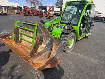 a green tractor that is parked in a parking lot