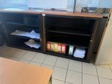 a desk with a book shelf and a computer monitor