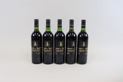 quatre bouteilles de vin sont alignées sur une surface blanche