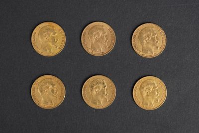 a close up of six different types of gold coins on a black surface
