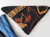 a black bandana with a gold and red design on it