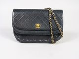 un sac Chanel noir muni d'une bandoulière en chaîne dorée