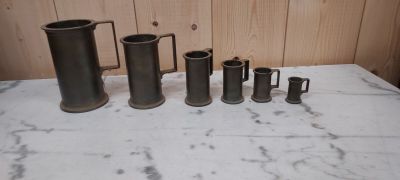 cinq vases de tailles différentes posés sur une table