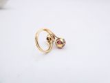 a close up of a pair of gold rings with garnets on them