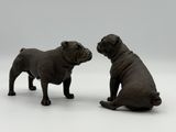 two figurines of a dog sitting next to each other