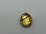 a close up of a gold pendant with a clock on it