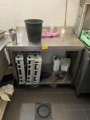 a kitchen with a sink, stove, and other items on the floor