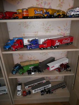 il y a beaucoup de petits camions jouets sur les étagères de la pièce