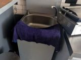 un évier et une poubelle dans une petite cuisine