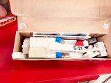 a box of toothbrushes and toothpaste on a red table