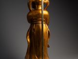 an image of a golden statue of a woman holding a lamp