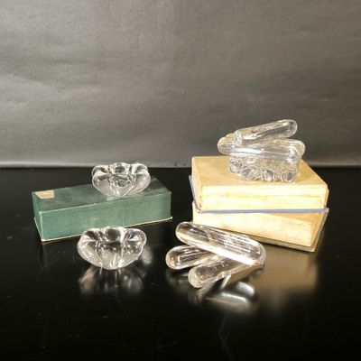 trois cendriers en verre et un livre posés sur une table noire