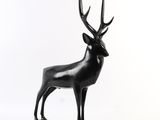 statue d'un cerf posée sur un socle en bois, sur fond blanc