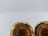 a pair of gold toned cufflinks with brown glass