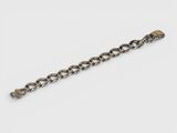 a close up of a chain bracelet with a skull on it