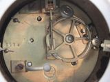a close up of a metal clock with a white face