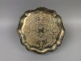 an antique silver plate with a floral design on it