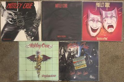 four cd ' s on a carpet with a guitar, a guitar, and a mask