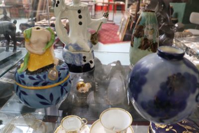 une table en verre sur laquelle sont disposés de nombreux vases différents