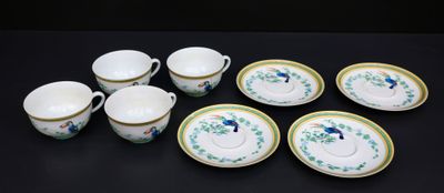 six tasses et une soucoupe posées sur une table noire