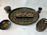 une assiette noire et dorée, ornée d'un motif noir et doré