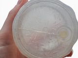a person holding a plastic container with a liquid inside of it