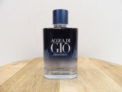 the bottle of acqua di gio is sitting on a wooden table