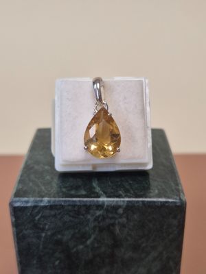 une image d'un pendentif auquel est suspendue une citrine sur le côté