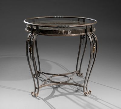 une table ronde avec un plateau en verre et des pieds en métal