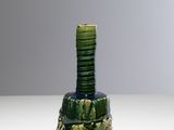un vase vert sur lequel est posée une pile de pièces de monnaie