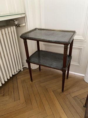 une petite table surmontée d'une étagère, placée dans un coin de la pièce