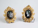 pair of gold and black picture frames with a man and woman on them