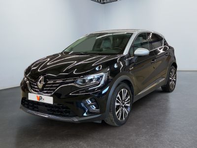 La voiture noire est garée dans une grande pièce où se trouve une horloge accrochée au mur.