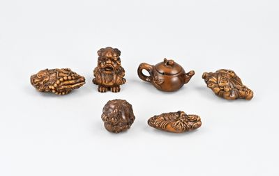 six petites figurines d'animaux en bois posées sur une surface blanche