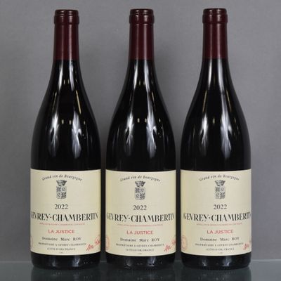 three bottles of red wine are lined up on a table
