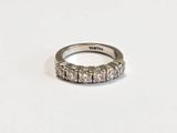 a close up of a diamond ring on a white surface