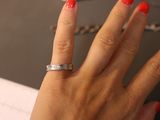 a woman ' s hand with a red manicure and a silver ring on it