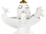 a white vase with a bird on it and a lamp on top