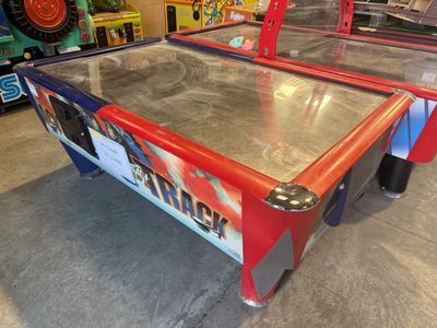 deux tables de hockey sur air dans une salle où se trouvent de nombreux jeux posés sur la table