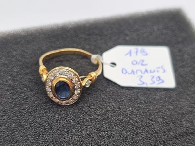 a close up of a gold ring with a sapphire and diamonds