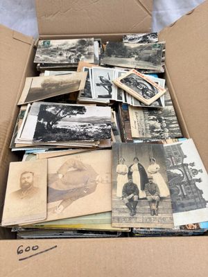 une boîte en carton remplie de vieilles photos de personnes