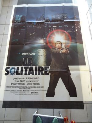 une grande affiche représentant un homme tenant une arme à feu dans une salle de bains