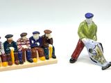 une figurine représentant un homme marchant à côté d'un groupe de figurines