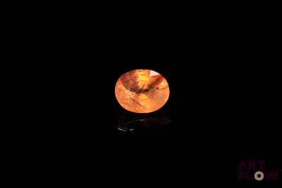 gros plan d'un diamant orange sur une surface noire