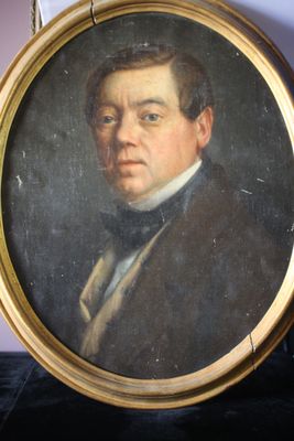tableau représentant un homme en costume et nœud papillon, dans un cadre doré