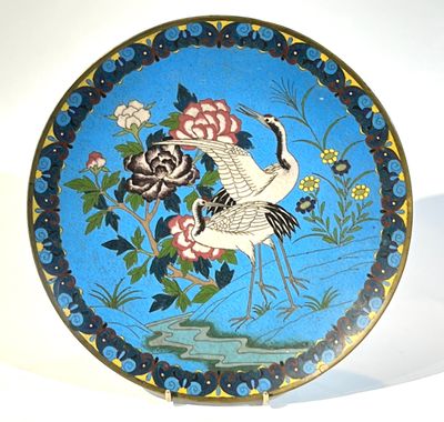 une assiette décorative ornée d'un oiseau et de fleurs