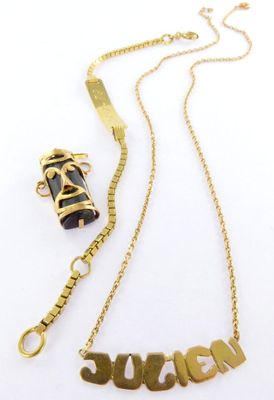 a close up of a necklace and a bracelet on a white surface